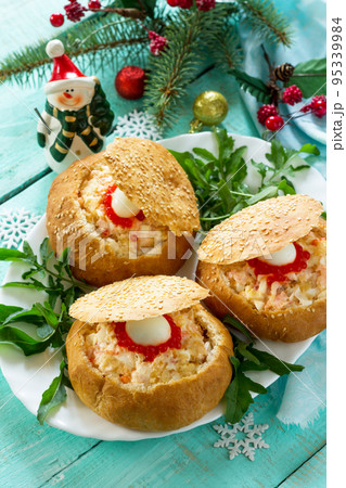 Festive appetizer on the Christmas table. Bun stuffed with shrimp salad and red caviar. 95339984