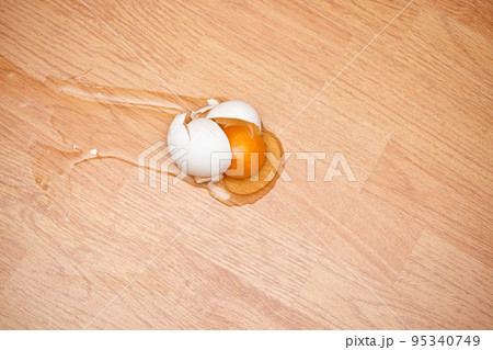broken egg on the wooden floor. broken egg on the wooden floor. 95340749