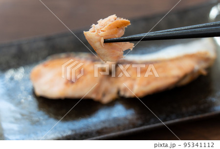 北海道産の焼き鮭を箸で持ち上げている 95341112