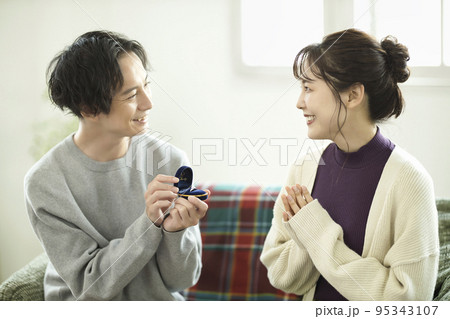 リビングでプロポーズする若い男性 95343107