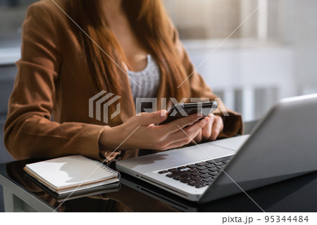Business people working in the work area with smartphone and laptop at the desk. Business people working in the work area with smartphone and laptop at the desk. 95344484