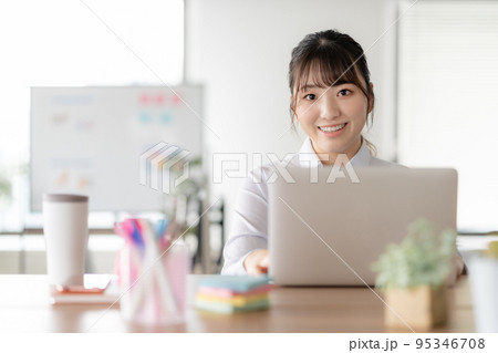 オフィスでパソコン作業をする若い女性 オフィスでパソコン作業をする若い女性 95346708