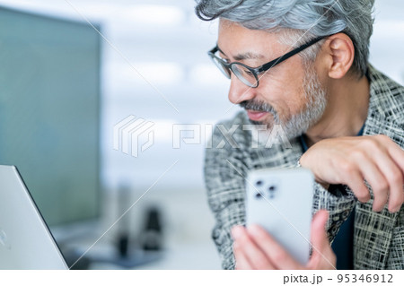 ビジネスマン　ミドル　エレガントな佇まい　携帯　スマホ 95346912
