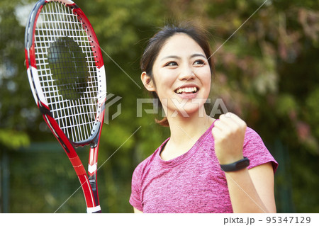 outdoor portrait of a happy asian woman female tennis player 95347129