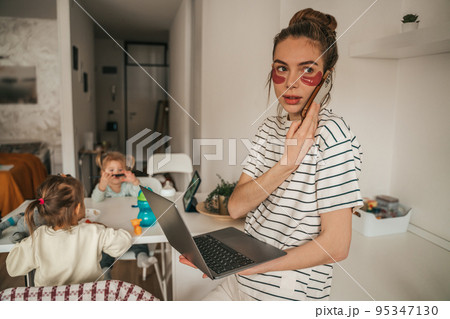 Busy freelance mom and kids playing in the kitchen Busy freelance mom and kids playing in the kitchen 95347130