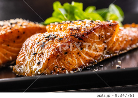 Two salmon fillets baked until crispy with sesame - Close up Two salmon fillets baked until crispy with sesame - Close up 95347761