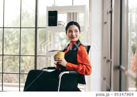 Relax business woman with coffee cup in office with window light. 95347904