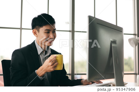 Business man working in office with computer drinking coffee Business man working in office with computer drinking coffee 95347906