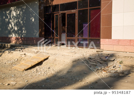 Destroyed entrance to the building, fragments of stairs and debris 95348187