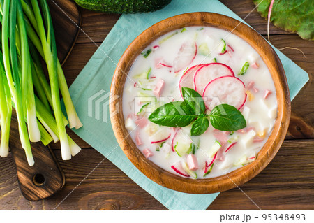 Russian kitchen. Okroshka - cold soup with vegetables, sausages and herbs on kefir. Rustic style. Top view Russian kitchen. Okroshka - cold soup with vegetables, sausages and herbs on kefir. Rustic style. Top view 95348493