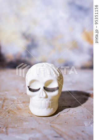 Cheerful Human skull with eyelashes. Background for copy space. 95351156