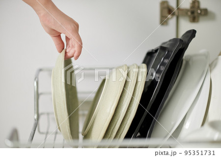 Closeup image of woman taking light green plate to serve breakfast Closeup image of woman taking light green plate to serve breakfast 95351731