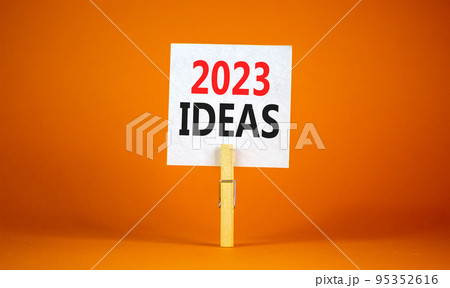 2023 Ideas symbol. White paper with words 2023 Ideas, clip on wooden clothespin. Beautiful orange table orange background. Business and 2023 ideas concept. Copy space. 2023 Ideas symbol. White paper with words 2023 Ideas, clip on wooden clothespin. Beautiful orange table orange background. Business and 2023 ideas concept. Copy space. 95352616