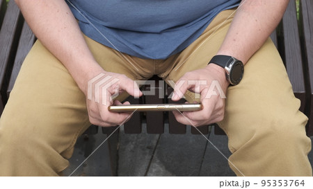 Gambling addiction. Close-up of modern smartphone in hands of adult man actively pressing on-screen buttons in computer game. Online casino, gambling Gambling addiction. Close-up of modern smartphone in hands of adult man actively pressing on-screen buttons in computer game. Online casino, gambling 95353764