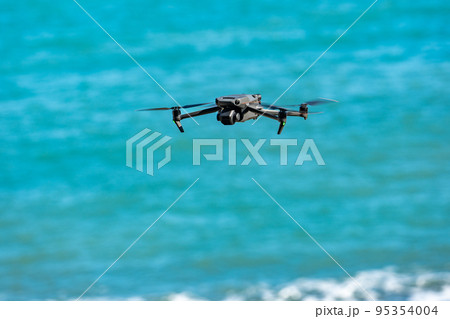 海岸を飛行するドローン 95354004