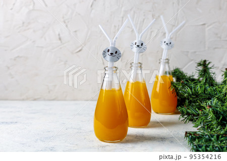 Orange drink decorated with white rabbit on light background for children party. 95354216