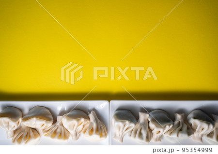 traditional georgian khinkali dumplings flatlay, copyspace, yellow background 95354999