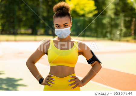Woman wearing protective face mask posing outdoors Woman wearing protective face mask posing outdoors 95357244