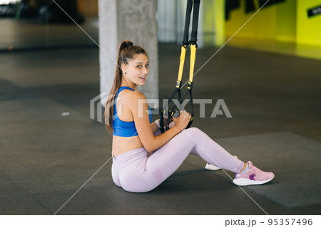 Woman doing exercises with trx fitness straps in the gym Woman doing exercises with trx fitness straps in the gym 95357496
