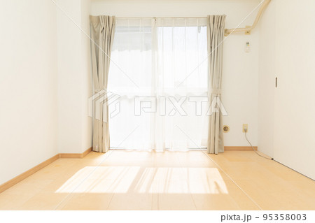 【日本】大きな窓から日光が差し込む白壁のフローリング居室 95358003