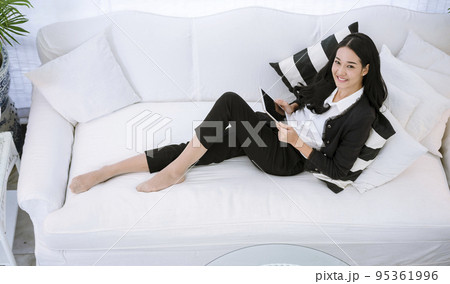 Asian woman using digital tablet shopping online, call, texting message internet technology lifestyle with smiling face. Asian woman touch smart tablet focus on hands using mobile app home office. 95361996