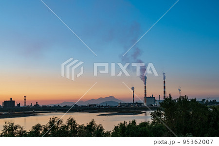 熊本県八代市の工業地帯の煙突が雲仙普賢岳をバックに白煙が上る風景 95362007