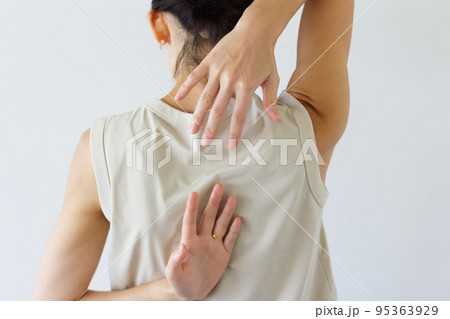 背中で手を組もうとする女性の後ろ姿 95363929