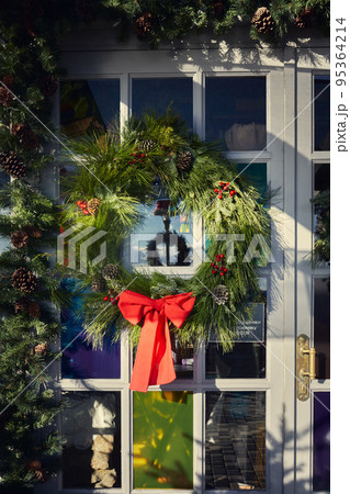 New Year and Christmas decorative wreath on the door. Vertical photo. New Year and Christmas decorative wreath on the door. Vertical photo. 95364214