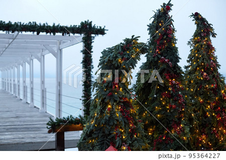 New Year and Christmas decorations on the seashore in winter. Yalta. Ate in garlands and beads. Front view. New Year and Christmas decorations on the seashore in winter. Yalta. Ate in garlands and beads. Front view. 95364227