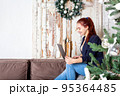 Young woman working from home. Christmas time.  95364485