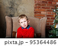 Caucasian boy sitting on chair. Christmas time. 95364486