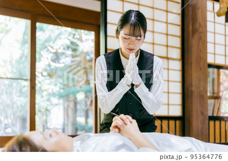 仏衣を着せる葬儀スタッフ（納棺師） 95364776