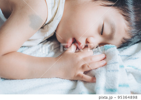 指しゃぶりしながら昼寝する2歳の男の子 指しゃぶりしながら昼寝する2歳の男の子 95364898