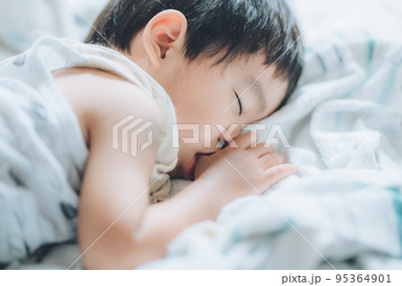 指しゃぶりしながら昼寝する2歳の男の子 指しゃぶりしながら昼寝する2歳の男の子 95364901