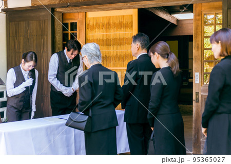 お葬式の受付でお辞儀する葬祭ディレクター(司会) お葬式の受付でお辞儀する葬祭ディレクター(司会) 95365027