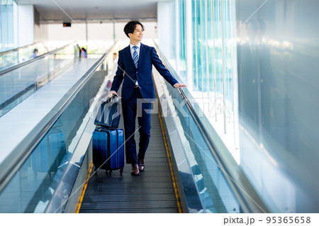 空港内の通路を歩くビジネスマン 95365658
