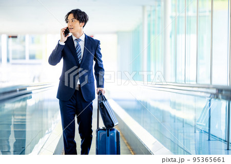 オフィスのロビーでスマホで電話する若いビジネスマン 95365661