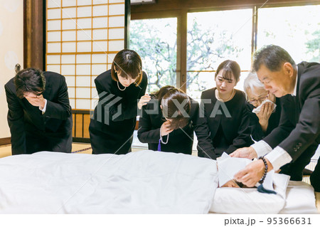 お葬式・お通夜で布団を囲み故人を弔う遺族（泣く） 95366631