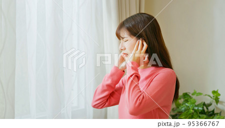asian woman is suffering noise 95366767
