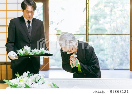 お葬式の納棺式で花入れの儀をする高齢者女性(合掌) お葬式の納棺式で花入れの儀をする高齢者女性(合掌) 95368121