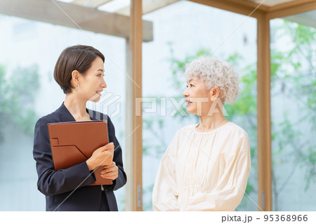 シニア女性と会話するビジネスウーマン シニア女性と会話するビジネスウーマン 95368966