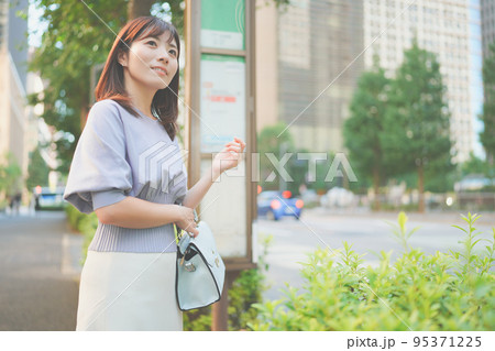 バス停でバスを待つ通勤中の女性	 95371225