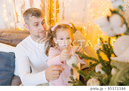 Happy father and children at home near Christmas tree. New Year and Christmas 95371386
