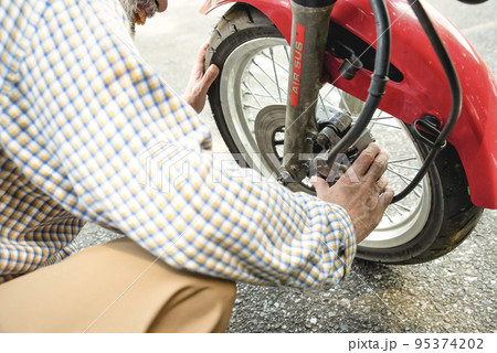 バイクライフ　バイクを整備するシニアライダーのイメージカット 95374202