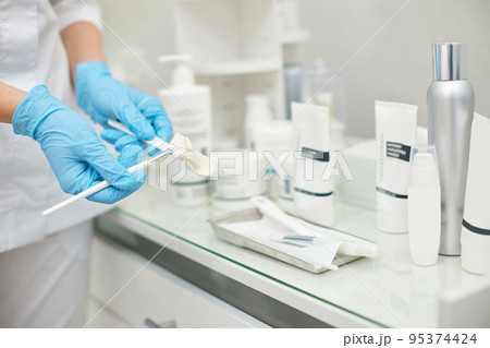 brush with cream in hands of beautician 95374424