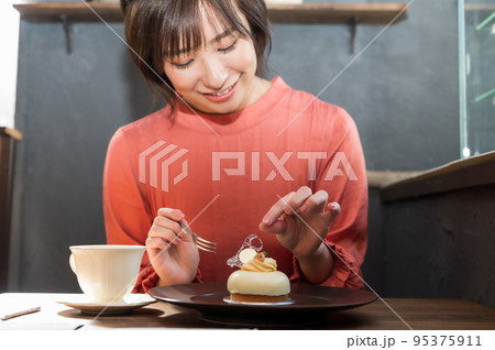 カフェでケーキを食べる女性 95375911