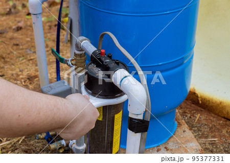 Maintenance is performed by professional worker who replace replaceable filters that are used to clean water near home Maintenance is performed by professional worker who replace replaceable filters that are used to clean water near home 95377331