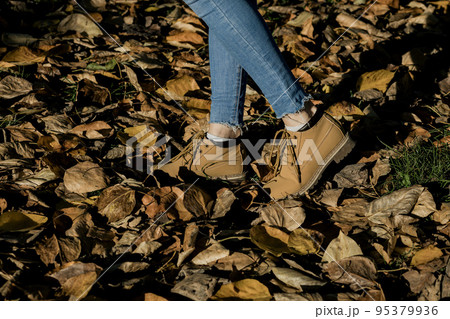 a woman in brown shoes walks in the park a woman in brown shoes walks in the park 95379936