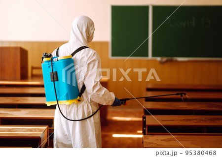 Disinfecting of office to prevent COVID-19, Man in protective hazmat suit with with spray chemicals. Disinfecting of office to prevent COVID-19, Man in protective hazmat suit with with spray chemicals. 95380468