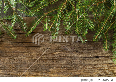 Green branches of spruce on an old wooden board Green branches of spruce on an old wooden board 95380518